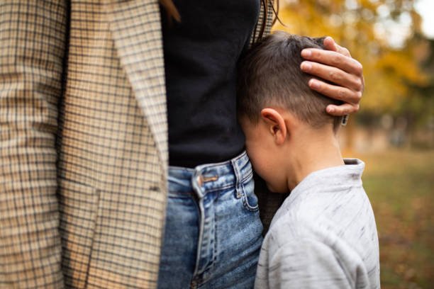 Child hiding behind his parent for mental health issues